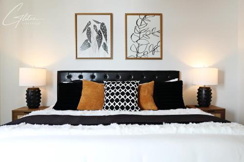 a bedroom with a black and white bed with two lamps at Modern Retreat 3 King Beds,Garage,Disney in Edmonton