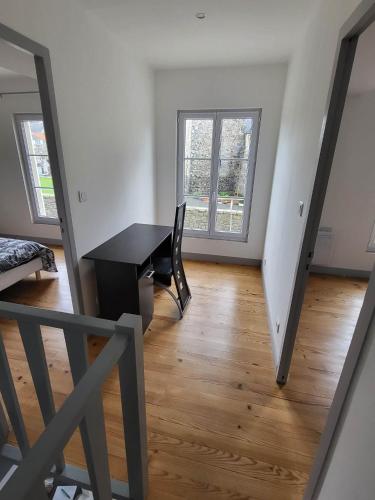 un salon avec une table et un bureau dans l'établissement Maison de charme, à Benoîtville