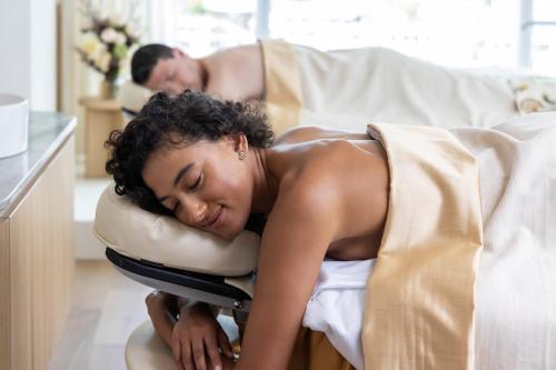 a woman laying on a bed next to a man at Sofitel Sydney Darling Harbour in Sydney