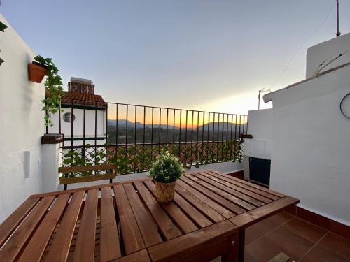 einem Holztisch auf einem Balkon mit Topfpflanze in der Unterkunft Casa Rural Villa Briar in Olvera