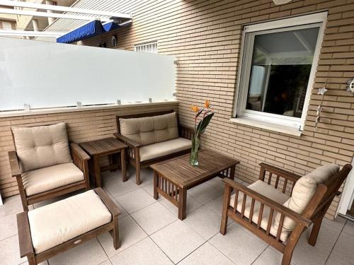 a patio with benches and tables and a window at UMA luna al sol Benicarlo-Peñiscola in Benicarló