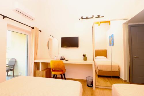 a bedroom with a desk and a mirror at Fegi Rooms in Himare