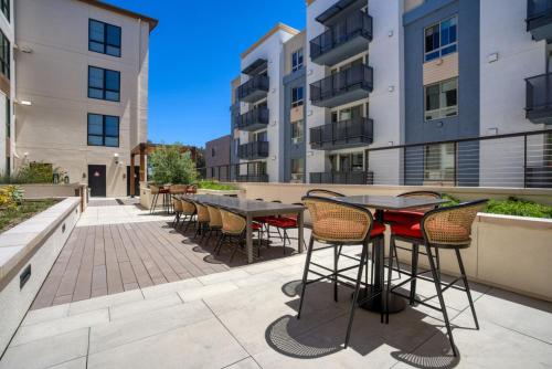 an outdoor patio with tables and chairs and buildings at San Mateo 1BR w Gym Roof WD nr Caltrain SFO-1044 in San Mateo