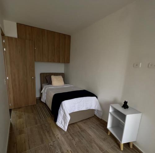 a small bedroom with a bed and a night stand at 601S Penthouse moderno con Parqueo Incluido in Ibagué