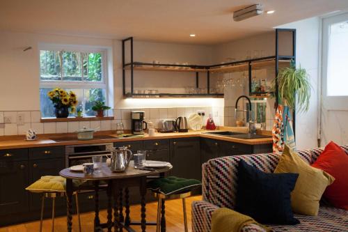 a kitchen and living room with a table and a couch at The Historical Harcourt Suites in Dublin