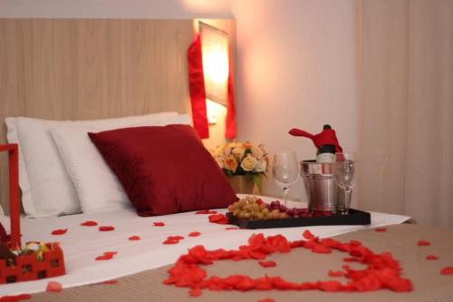 a bedroom with a bed with red roses on it at POUSADA ACONCHEGO MT in Chapada dos Guimarães