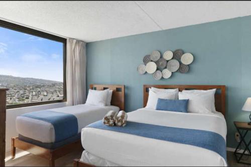 2 camas en una habitación con ventana grande en Views! Mountains, Canal, and City! en Honolulu