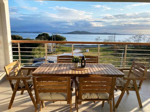 una mesa de madera en un balcón con vistas al agua en Casa al Mare, en Nea Roda