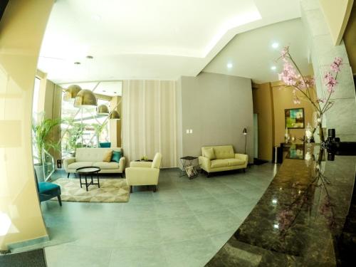 a living room with yellow furniture and a lobby at Hotel Viaggiatore in Cochabamba