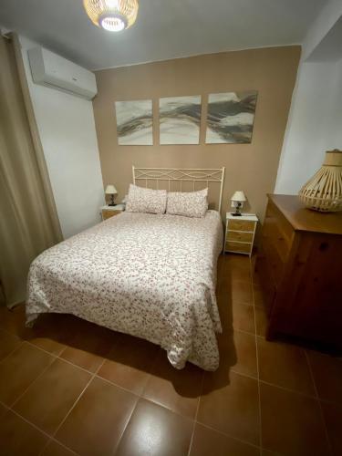 a bedroom with a bed and two paintings on the wall at Casa Rural Villa Briar in Olvera