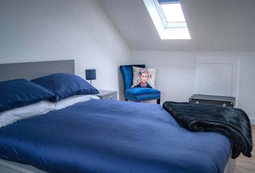 a bedroom with a blue bed and a blue chair at The Red House- 3 Parking Spaces Walking Distance to City Centre and Cardiff Bay 3 dbl bedrooms in Cardiff