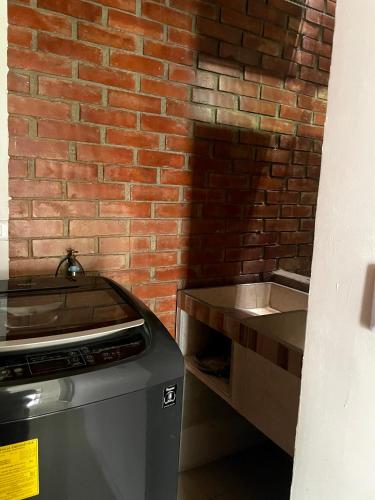 a kitchen with a brick wall next to a counter at APARTA HOTEL Y TERRAZA SAMANES in Florida