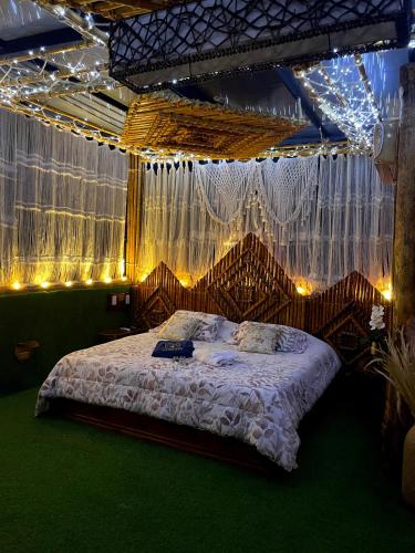 a bedroom with a bed with lights and curtains at APARTA HOTEL Y TERRAZA SAMANES in Florida