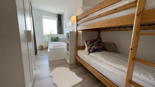 クックスハーフェンにあるStrandhaus-Nordseebrandung-Fewo-A1-4の二段ベッド2台と廊下が備わる客室です。