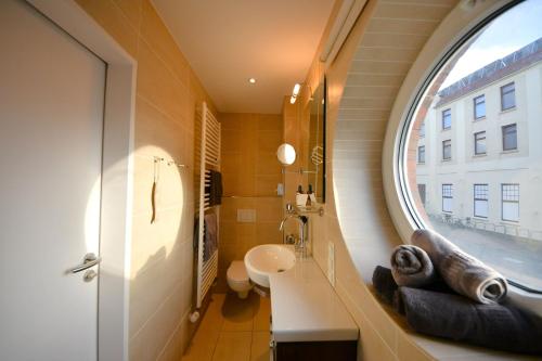 a bathroom with a sink and a large window at Haus Poseidon - Wohnung 1 1 in Wangerooge