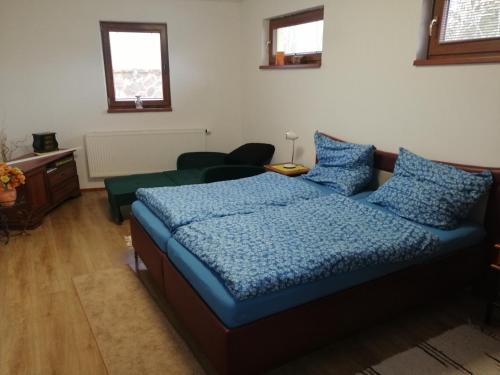 a bedroom with a bed with a blue comforter at Útulný Domček Privat Bedrich in Poprad