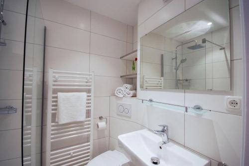 uma casa de banho branca com um lavatório e um espelho em Frische-Brise-10-05 em Cuxhaven