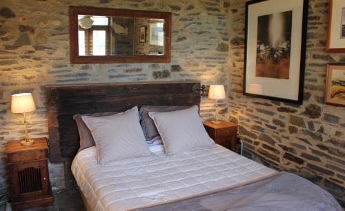 een slaapkamer met een bed met een spiegel en 2 lampen bij Stables by the Vines in Mintaro