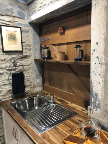 una cocina con fregadero en una casa pequeña en Stables by the Vines en Mintaro
