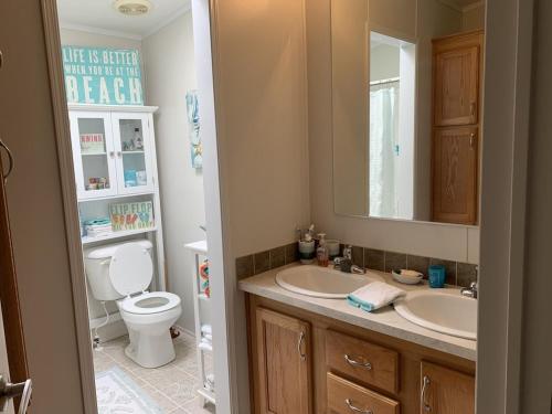 ein Badezimmer mit einem Waschbecken, einem WC und einem Spiegel in der Unterkunft Amazing Views near Grand Canyon Skywalk in Meadview
