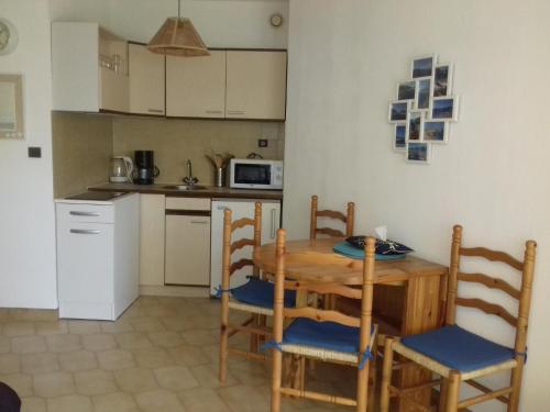 - une cuisine avec une table et des chaises en bois dans la chambre dans l'établissement Beau studio vue mer Canet Sud, à Canet