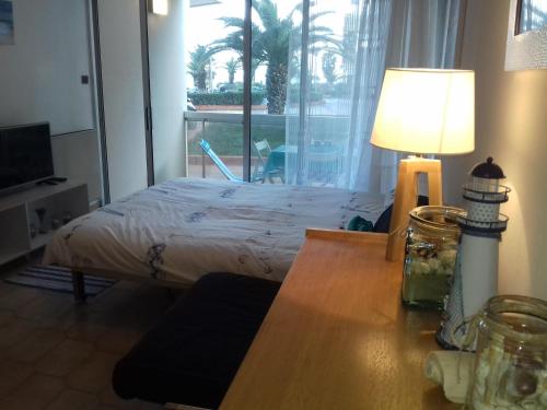 sypialnia z łóżkiem i stołem z lampą w obiekcie Beau studio vue mer Canet Sud w mieście Canet-en-Roussillon
