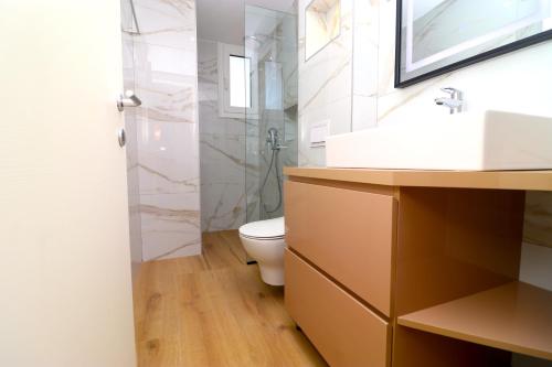a bathroom with a toilet and a sink and a shower at Fegi Rooms in Himare