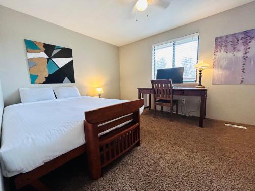 - une chambre avec un lit et un bureau avec un ordinateur dans l'établissement Luxe on Penn Family Friendly, Toddler amenities, baby proof with baby gate, toys, bath toys, cups and plates, Separate Workstation with Desk and Monitor, located in desirable SE Boise next to the Greenbelt and Boise River, à Boise