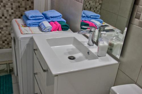 La salle de bains est pourvue d'un lavabo, d'un miroir et de serviettes. dans l'établissement Apartament Tenerife-Tabaiba, à Tabaiba