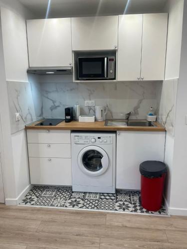 eine Küche mit einer Waschmaschine und einer Mikrowelle in der Unterkunft Studio proche Stade de France in Saint-Denis