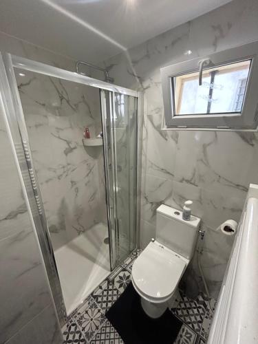 a white bathroom with a shower and a toilet at Studio proche Stade de France in Saint-Denis
