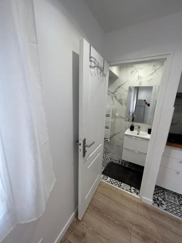 ein Badezimmer mit einer weißen Tür und einem Waschbecken in der Unterkunft Studio proche Stade de France in Saint-Denis