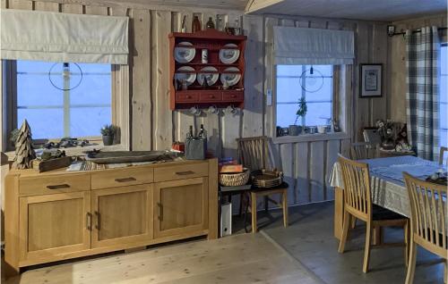 eine Küche mit Holzschränken sowie einem Tisch und Stühlen in der Unterkunft Awesome Home In Treungen With Wifi in Treungen