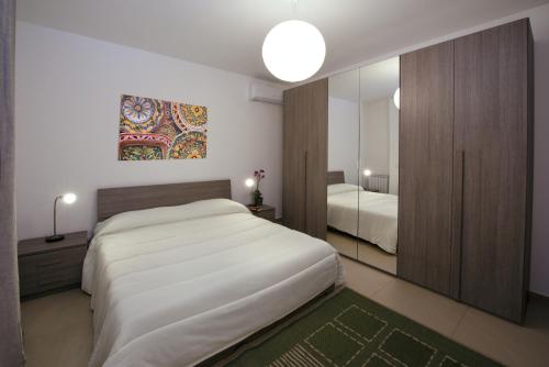 a bedroom with a large white bed and a mirror at Residence Rapisardi by RECEPTIO in Catania