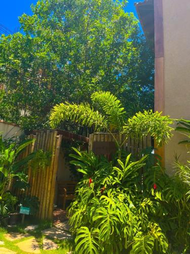 a garden with a wooden fence and some plants at Casa d'Aroeira Residencial Boutique - Centro de Juqueí - 2 quadras do mar - Serviço de Praia - Roupa de Cama 600 fios algodão Egípcio - Toalhas Banho e Praia - Tudo Novo - Estacionamento Interno - Cozinha - Consulte unidades com Ofurô Hidro e Cromoterapia in Juquei