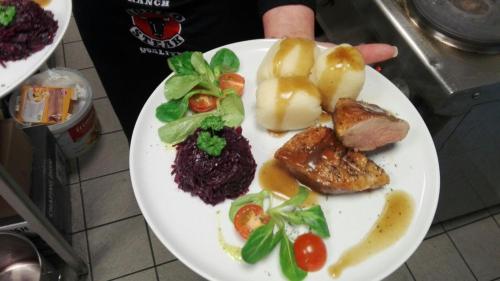 a plate of food with meat and vegetables on it at AnaCapri Gästehaus Verona in Ueckermünde