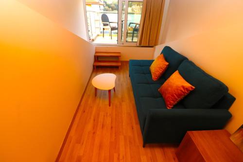 a living room with a blue couch and a window at Fegi Rooms in Himare