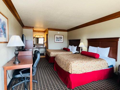 a hotel room with two beds and a desk and a computer at Cattle country lodge in Stroud