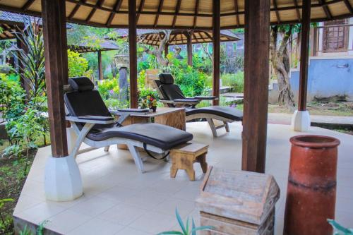 a group of chairs and tables in a pavilion at Araminth Guest House and Spa in Lovina