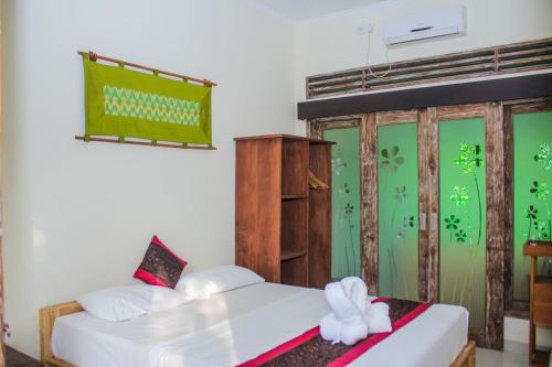 a bedroom with two beds and a green wall at Araminth Guest House and Spa in Lovina