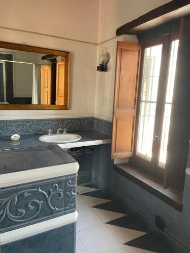 y baño con lavabo y espejo. en Habitación Azul triple con gran jardín !! en San Isidro