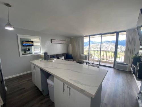 a kitchen with a counter and a living room at Nalu Malu 1 Bedroom @Waikiki Banyan 1 Free Parking in Honolulu
