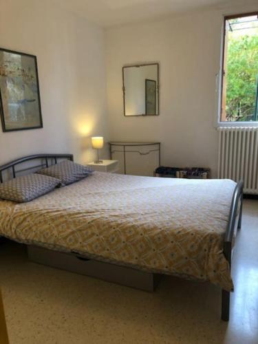 une chambre avec un lit et un miroir au mur dans l'établissement BEL APPARTEMENT 4Pers RDC/parking/terrasse/ jardin, à Collioure