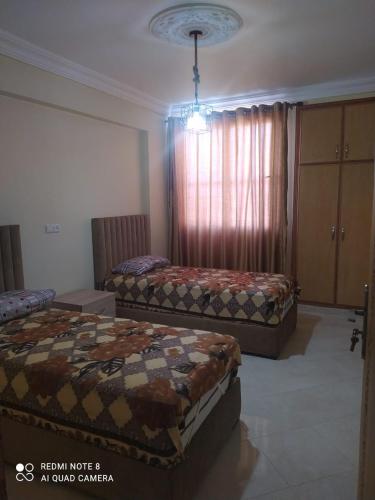 um quarto com duas camas num quarto com uma janela em Berkane carrefour em Oujda