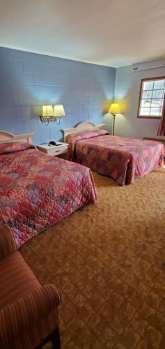 um quarto de hotel com duas camas e duas lâmpadas em Deluxe Inn Jasper em Jasper