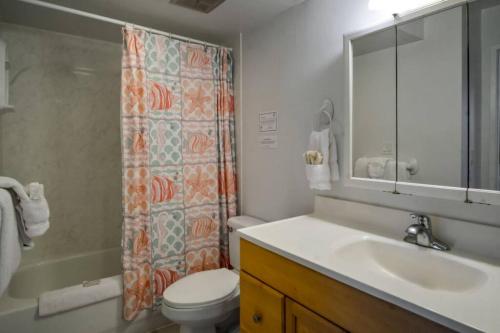 a bathroom with a sink and a toilet and a mirror at Rec Deck Suite, 1 Bed Condo + Free Parking in Honolulu