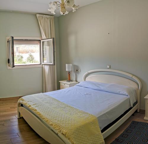 een witte slaapkamer met een bed en een raam bij Seaside Serenity Kefalos in Kefalos