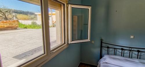 a bedroom with a window looking out onto a deck at Seaside Serenity Kefalos in Kefalos