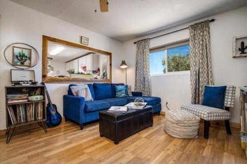 a living room with a blue couch and a mirror at Starfire Relaxation Retreat in Joshua Tree