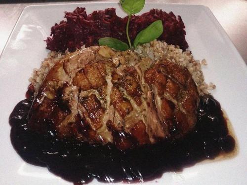 a plate of food with meat and blueberry sauce at Gościniec Biznesowy in Dąbrowa Górnicza